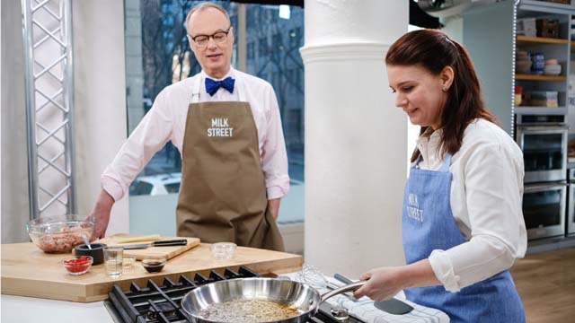 Host Christopher Kimball instructing Lynn Clark on how to prepare a dish